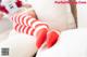 A person laying on a bed with red and white striped stockings.