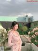 A woman standing in front of a bunch of flowers.