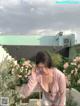 A woman standing in front of a bunch of flowers.