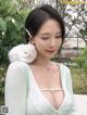 A woman holding a white cat on her shoulder.