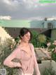 A woman standing in front of a green building.