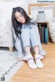 A woman sitting on the floor wearing a pair of socks.