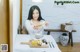 A woman sitting at a table with a plate of food.