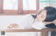 A woman leaning on a railing with her head resting on her hand.