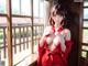 A woman in a red kimono posing by a window.