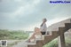 A woman sitting on the steps of a concrete building.