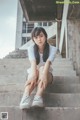 A woman sitting on the steps of a building.