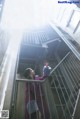 A woman in a purple coat is standing on a stairwell.