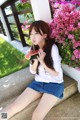 A woman sitting on the steps eating a slice of watermelon.