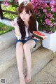 A woman sitting on the steps eating a slice of watermelon.