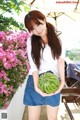 A woman holding a watermelon in her hands.