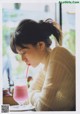 A woman sitting at a table with a drink in her hand.