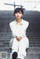 A woman sitting on the steps of a building.