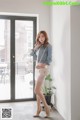 a woman standing in front of a window talking on a cell phone