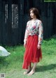 A woman standing in front of a black fence.