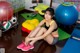 A woman sitting on the floor in a gym.