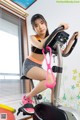 A woman riding an exercise bike in a room.