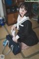 A woman in a school uniform sitting on the floor.