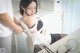 A woman in a black bra top and black stockings is tied up to a chair.
