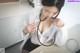 A woman in a white lab coat holding a stethoscope.