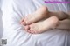 A pair of bare feet laying on a bed.