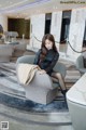 A woman sitting on a chair in a hotel lobby.