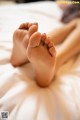 A close up of a person's feet on a bed.