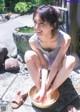 A woman sitting on the ground with a bowl of water.