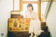 A woman sitting on a set of stairs next to a suitcase.