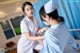 A nurse is checking a patient's heartbeat with a stethoscope