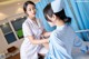 A nurse is examining a patient's chest with a stethoscope.