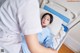 A woman laying in a hospital bed next to a nurse.