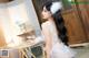 A woman in a white dress sitting on a chair.