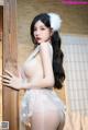 A woman in a white lingerie leaning against a wooden door.