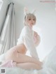 A woman in a bunny costume sitting on a bed.