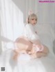 A woman in a bunny costume sitting on a bed.