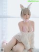 A woman in a bunny costume sitting on a bed.