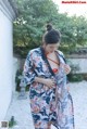 A woman in a blue and red kimono is posing for a picture.