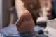 A close up of a person's foot on a bed.