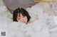 A woman laying on top of a bed covered in white clouds.