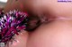 A close up of a woman's face with a pink and silver pom pom.