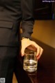 A person holding a glass of water on a table.