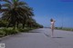 A naked woman walking down the middle of a road.