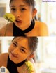 A woman holding a yellow rose in her mouth.