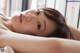 A woman laying on top of a bed next to a window.