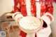 A person in a santa suit holding a bowl of white balls.