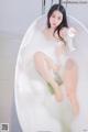 A woman sitting in a bathtub filled with foam.