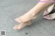 A close up of a woman's bare feet wearing pink shoes.