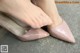 A close up of a woman's feet wearing pink shoes.