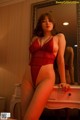 A woman in a red lingerie posing in front of a mirror.